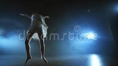 现代芭蕾舞女光着脚在舞台上慢吞吞地跳着旋转和旋转木马，跳着舞步